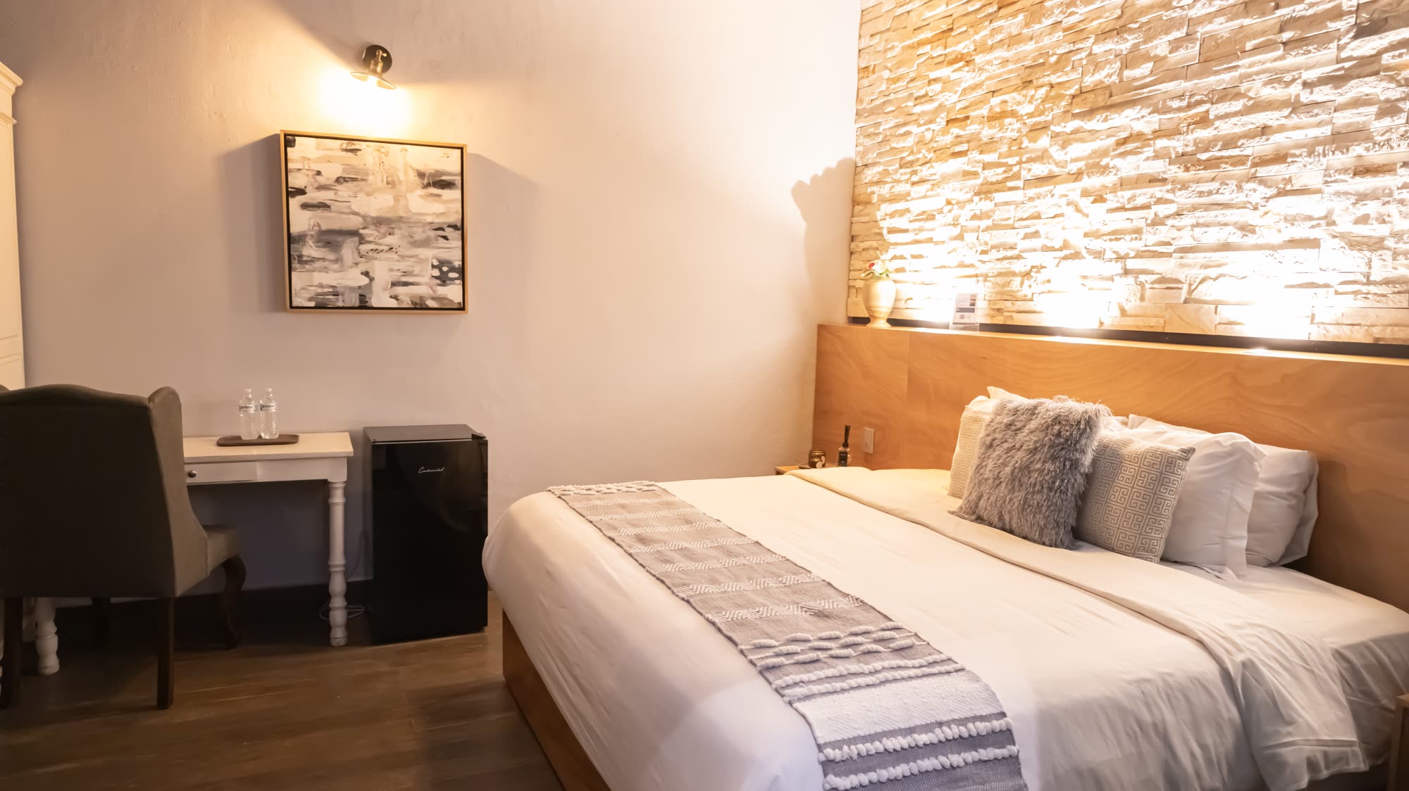 La habitación Deluxe 209 con escritorio y muro de piedra