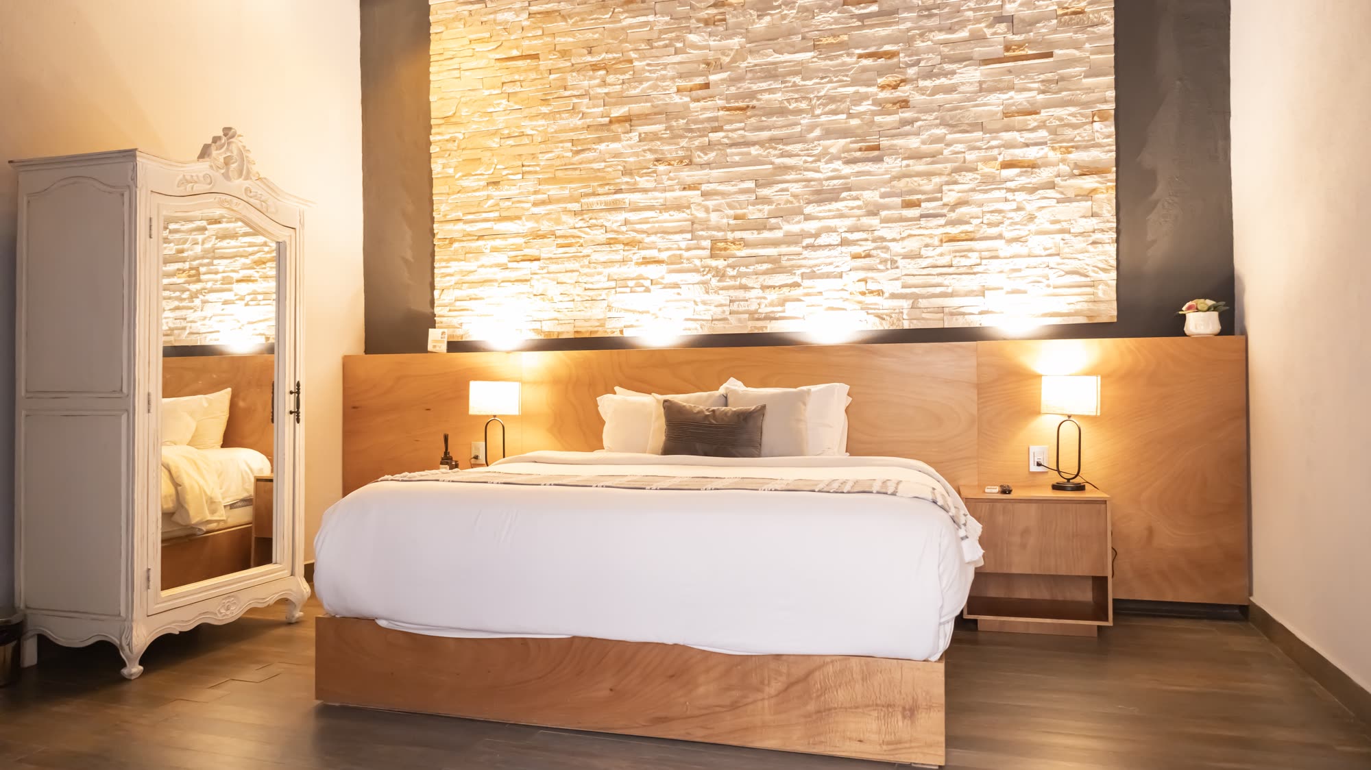 La cama de la Jr Suite 206 con el armario blanco
