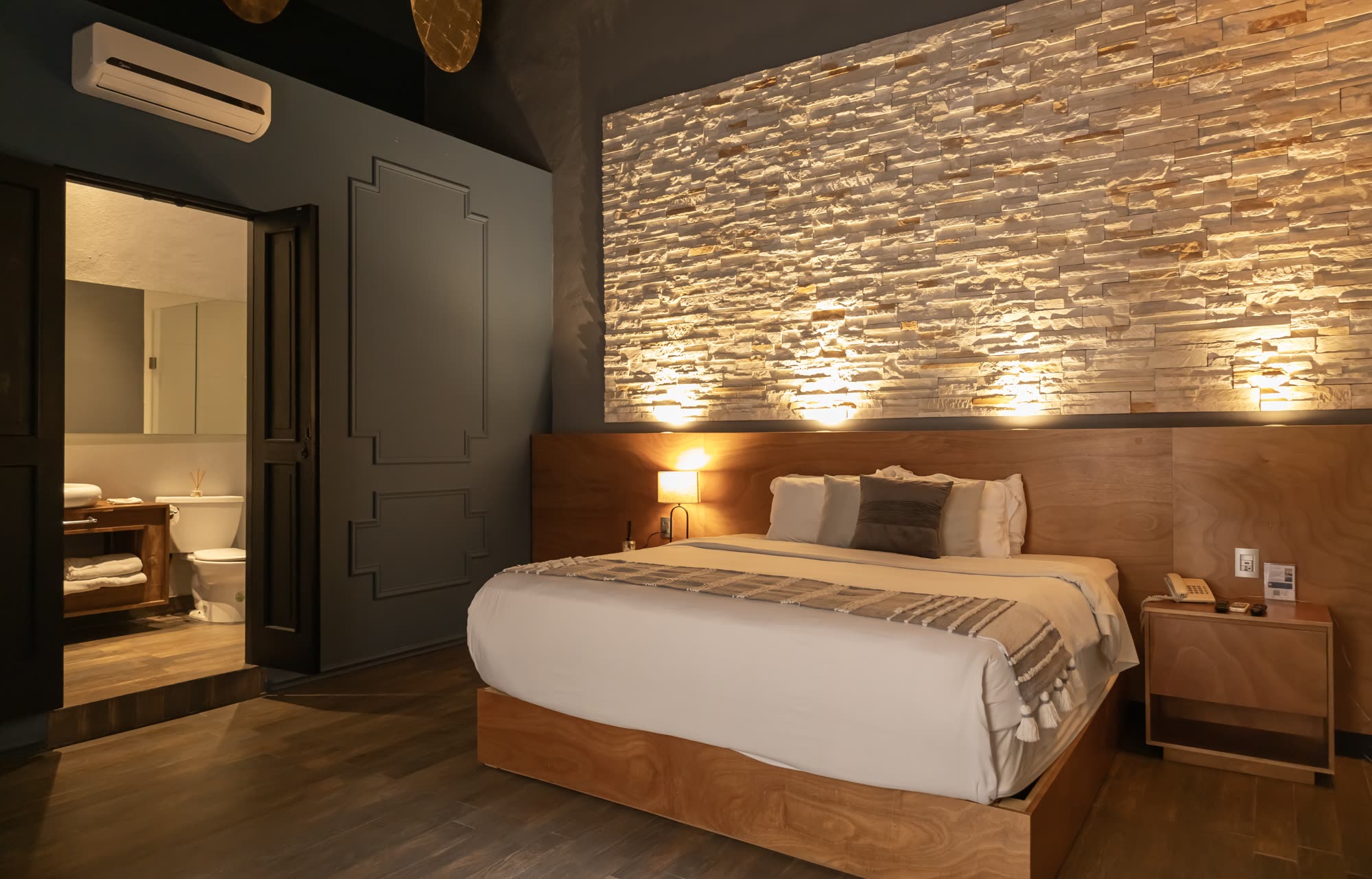 La Jr Suite 208 con su muro de piedra iluminado