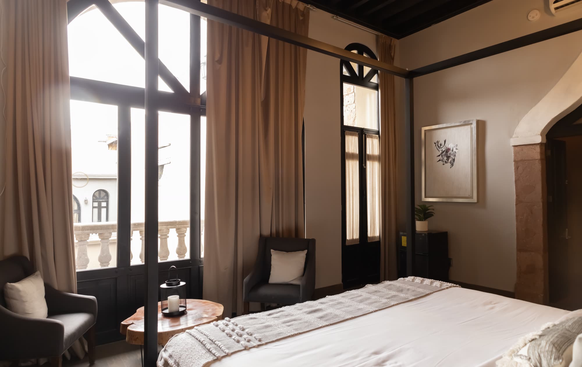 La estancia de la Master Suite 204 junto a los ventanales de arco