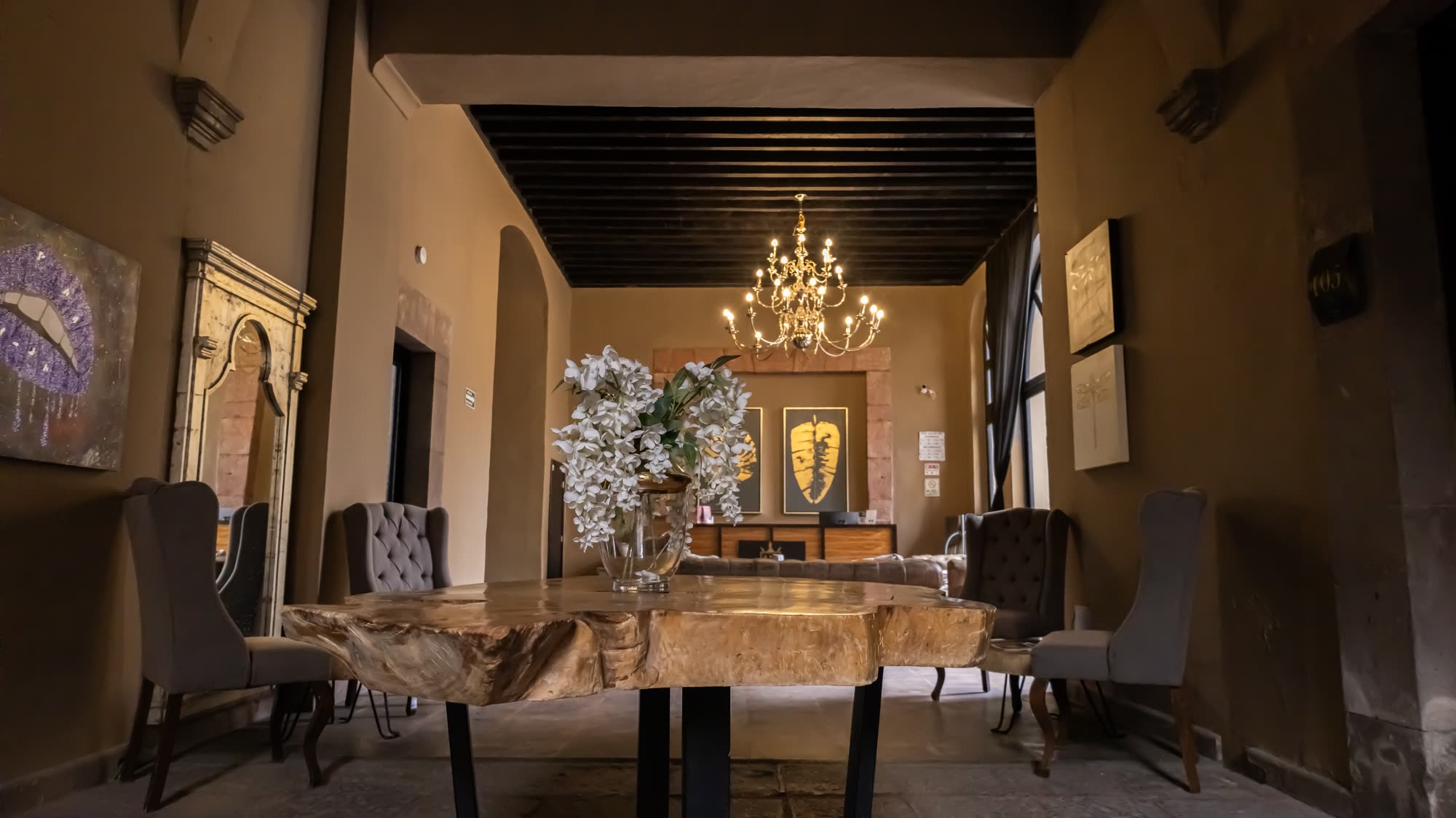 Salón comedor colonial con techo de vigas y candelabro