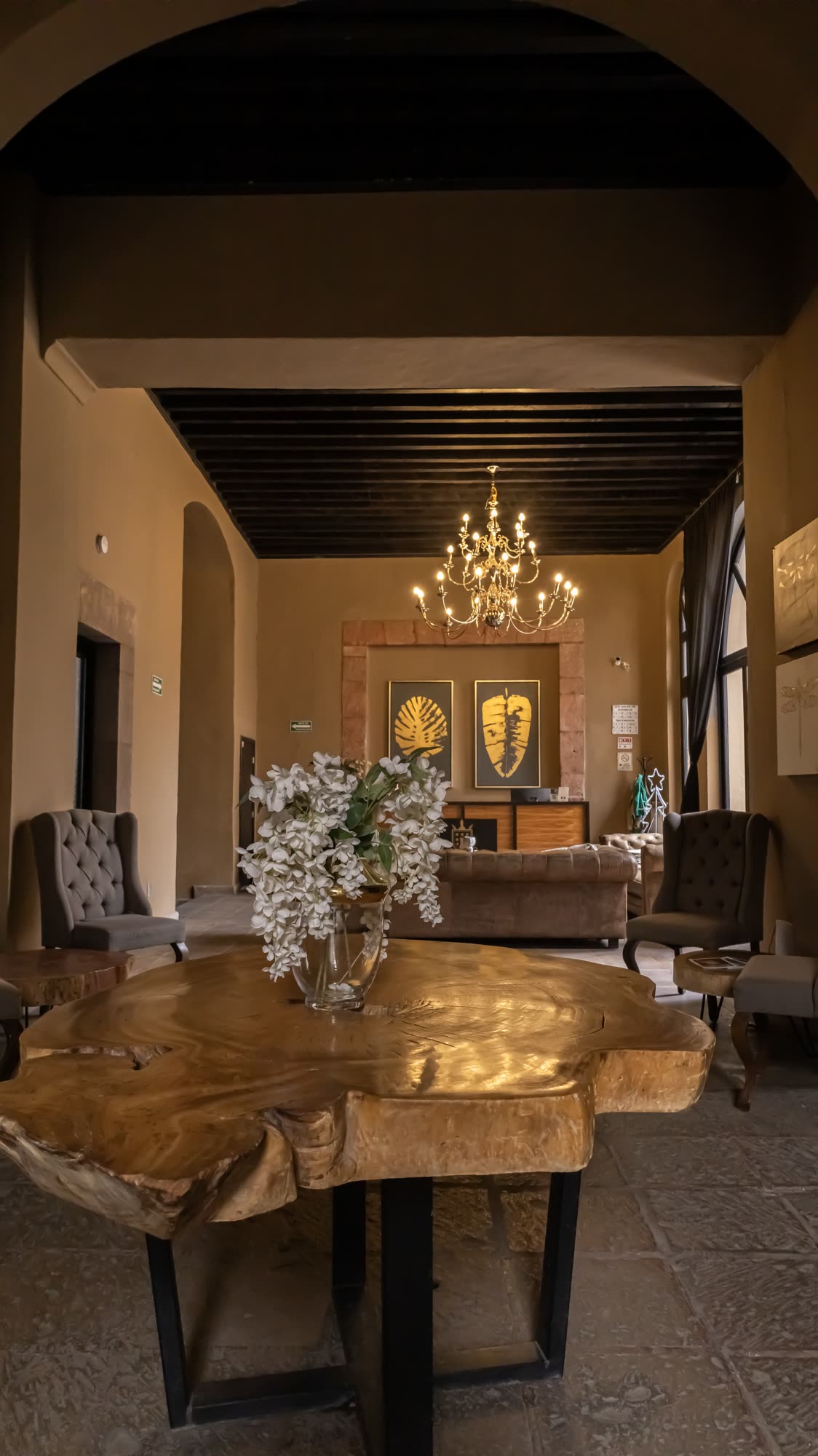 Salón comedor del hotel con mesa de madera maciza bajo el candelabro
