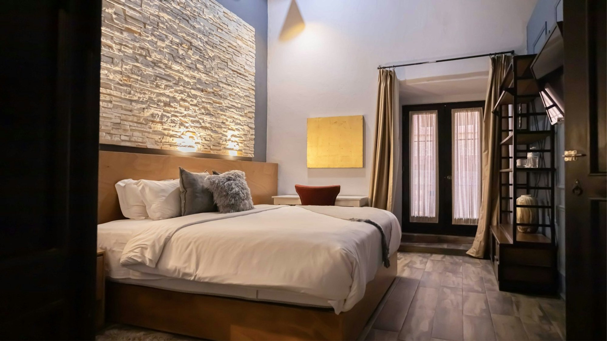 La habitación Standard con su cama Queen y las puertas de vidrio con cortina